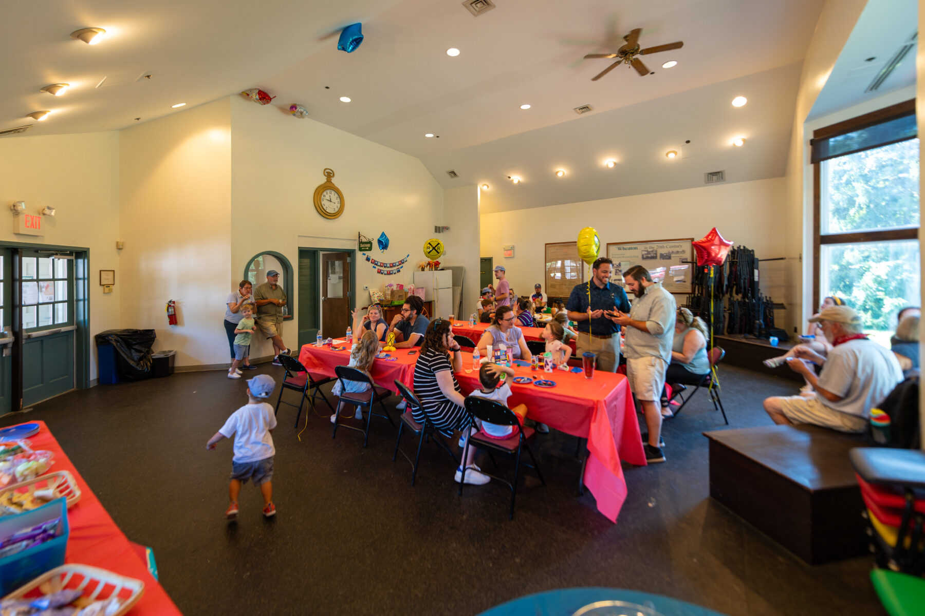 A group gathers in a party room to celebrate a birthday party